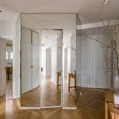 an empty room with large mirrors on the wall and wooden floors in front of it