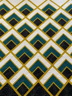 a close up view of a quilt with blue and yellow squares on it's edges