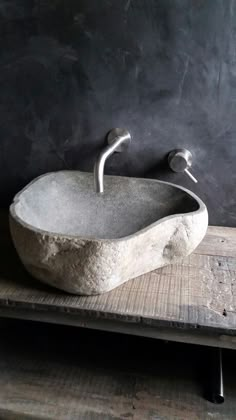 a stone sink sitting on top of a wooden table