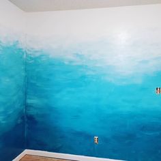 an empty room with blue paint on the walls