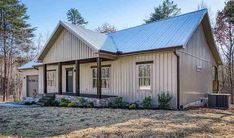 a small house with a metal roof in the woods