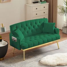 a green couch sitting on top of a hard wood floor next to a white rug