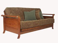 a wooden frame couch with green pillows on it's back and armrests