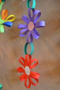 colorful paper flowers are hanging from a string