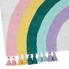 a rainbow rug with tassels on it