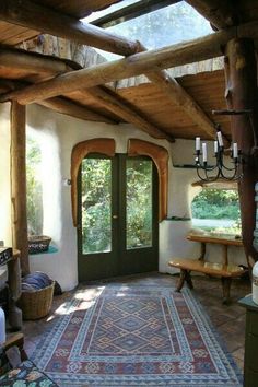 the inside of a house with a green door and wooden beams on the ceiling is covered in wood planks