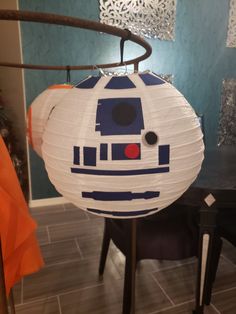 a paper lantern shaped like a star wars r2d - d2 sits on top of a table