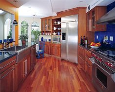 a kitchen with wooden floors and stainless steel appliances