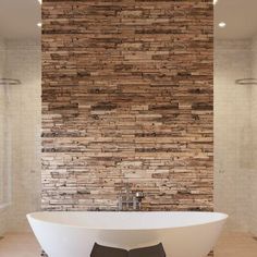 a large white bath tub sitting next to a brick wall