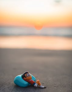 a small toy sitting on top of a sandy beach