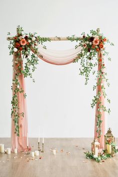 a wedding arch decorated with flowers and candles