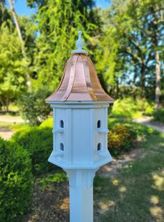 a white post with a copper top in the park