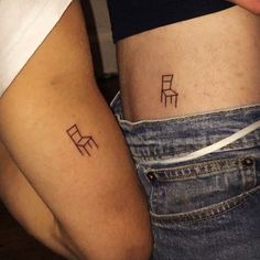 two people with tattoos on their stomachs are holding each other's butts