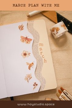 an open book sitting on top of a table next to some markers and pencils