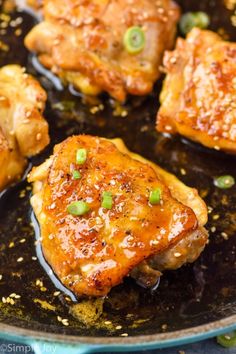 chicken thighs in a skillet with green onions and seasoning on the side, ready to be cooked