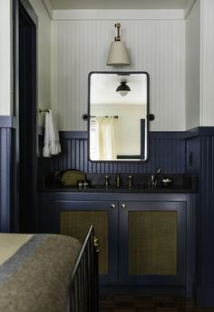 an image of a bathroom with dark blue cabinets