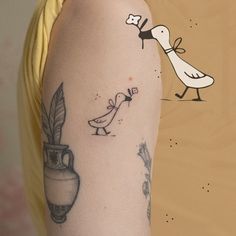 a woman with a bird and vase tattoo on her left arm, next to a wall