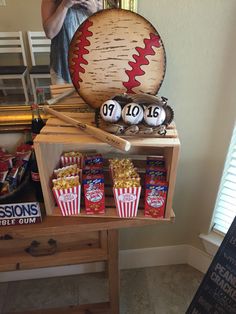 a baseball themed party with popcorn and other items on a table in front of a mirror