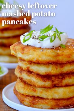 a stack of pancakes topped with whipped cream and green leafy garnishments