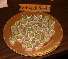 there is a plate full of sushi rolls on the table with a sign in the background