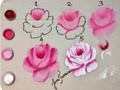 some pink flowers are sitting on a white surface with buttons and markers to paint them