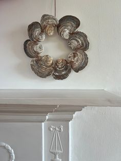 a wreath hanging on the wall above a fireplace