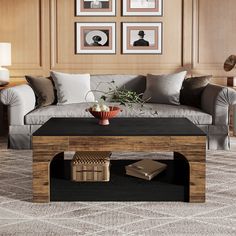 a living room filled with furniture and framed pictures on the wall above a coffee table