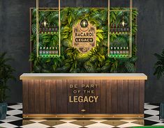 the bar is decorated with green plants and gold letters that read be part of the legacy