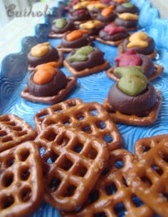 a blue plate topped with lots of pretzels covered in chocolate