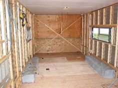 the inside of a house being built with wooden walls and floor joists in place