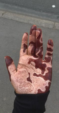 a person's hand covered in brown and white paint on the palm of their left hand