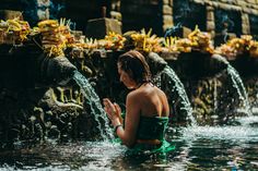 a woman is sitting in the water and praying