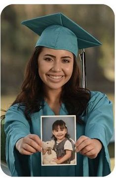 a woman in a graduation cap and gown holding up a photo