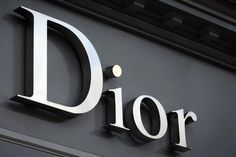 a sign that says dior is on the side of a building with metal letters