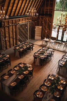 an overhead view of tables and chairs in a barn with chandeliers hanging from the ceiling