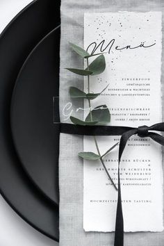 a black plate with a napkin tied around it and a flower on the side that says menu