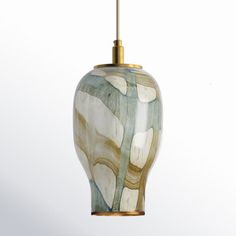 a green and white glass light hanging from a gold colored ceiling fixture in a room