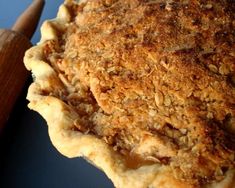 a close up of a pie on a blue plate with a wooden spatula next to it