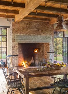 an old brick fireplace in the middle of a dining room