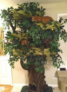 a cat is sitting on top of a fake tree