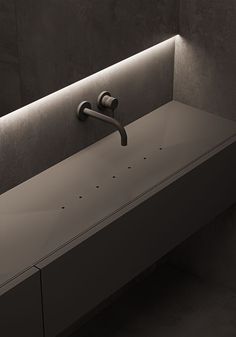 a bathroom sink with two faucets and lights on the wall above it in black and white