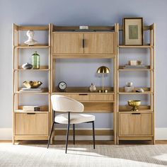 a chair and desk in front of a bookshelf with shelves on the wall