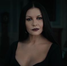 a woman with long black hair and dark lipstick