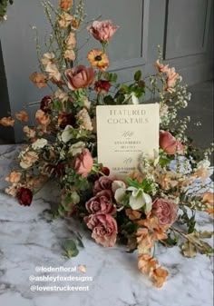 an arrangement of flowers on a table with a sign that says,'featured goods '