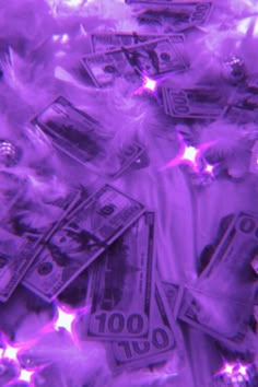 purple feathers and money are scattered on top of each other in this artistic photo by the photographer