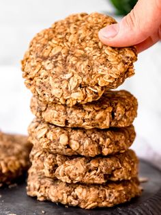 a stack of oatmeal cookies being held by a hand