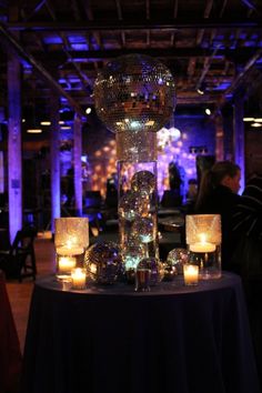 the centerpiece is surrounded by candles and glass balls