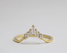 a yellow gold ring with three baguettes in the middle and two diamonds on each side