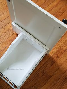 an open white box sitting on top of a wooden floor