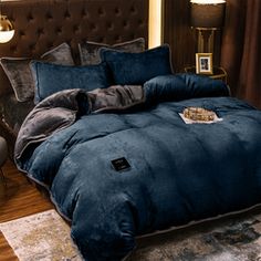 a blue comforter set on a bed in a bedroom